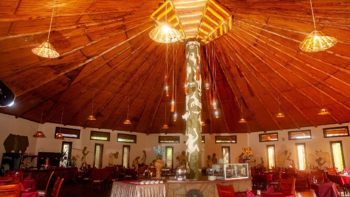 Circular thatched dining hall with wooden beams and pendant lighting at AA Lodge Amboseli.