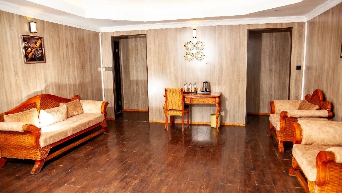 Lounge seating area with wooden furniture and patterned cushions at AA Lodge Amboseli.
