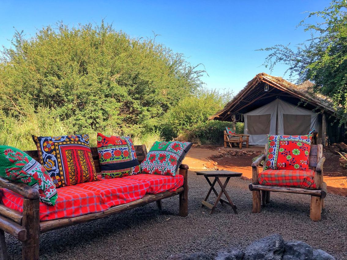 Colorful cushioned seating nook beside the tents at Amboseli Bush Camp.