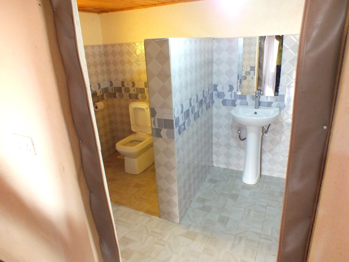En-suite bathroom with a toilet and washbasin in a guest room at Amboseli Mountain View Camp.
