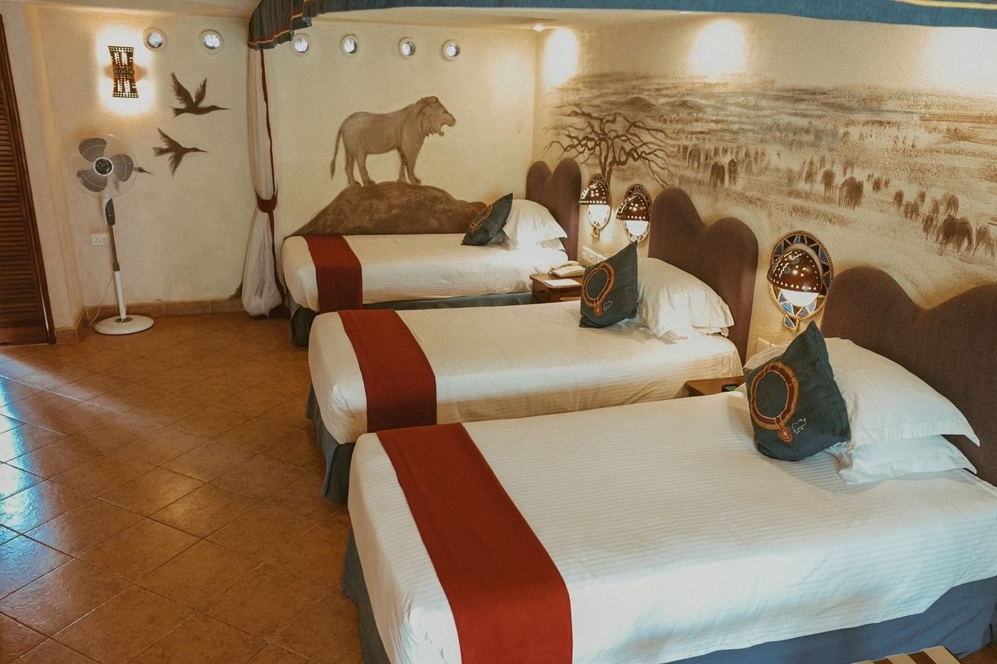 Twin beds with wildlife-print headboards and lake-blue accents in a room at Amboseli Serena Safari Lodge.