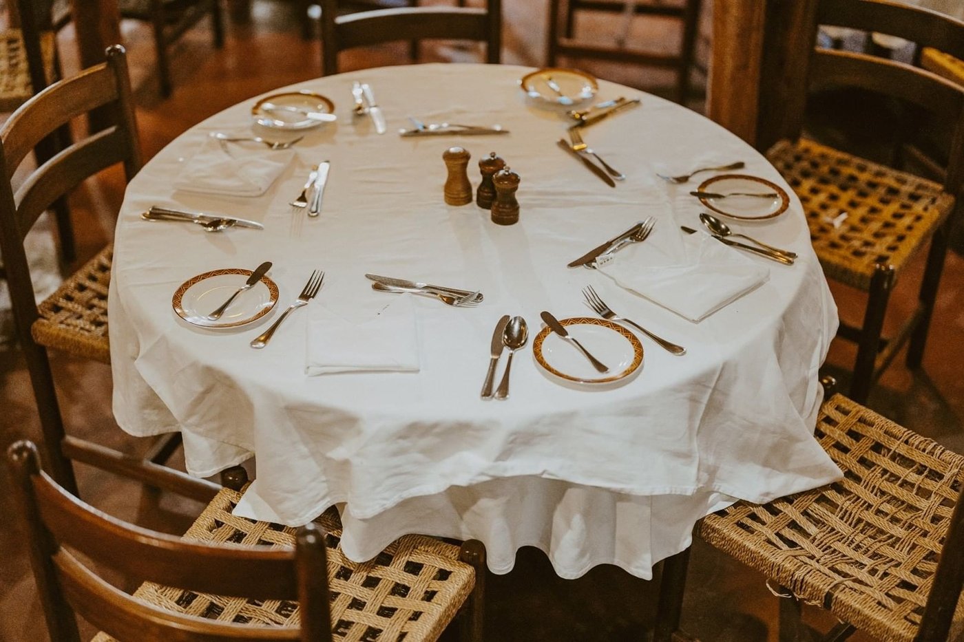 Round dining table set with white linen and polished glassware at Amboseli Serena Safari Lodge.