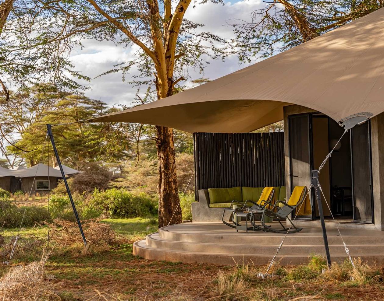 Shaded deck and lounge chairs outside a guest tent at Angama Amboseli.