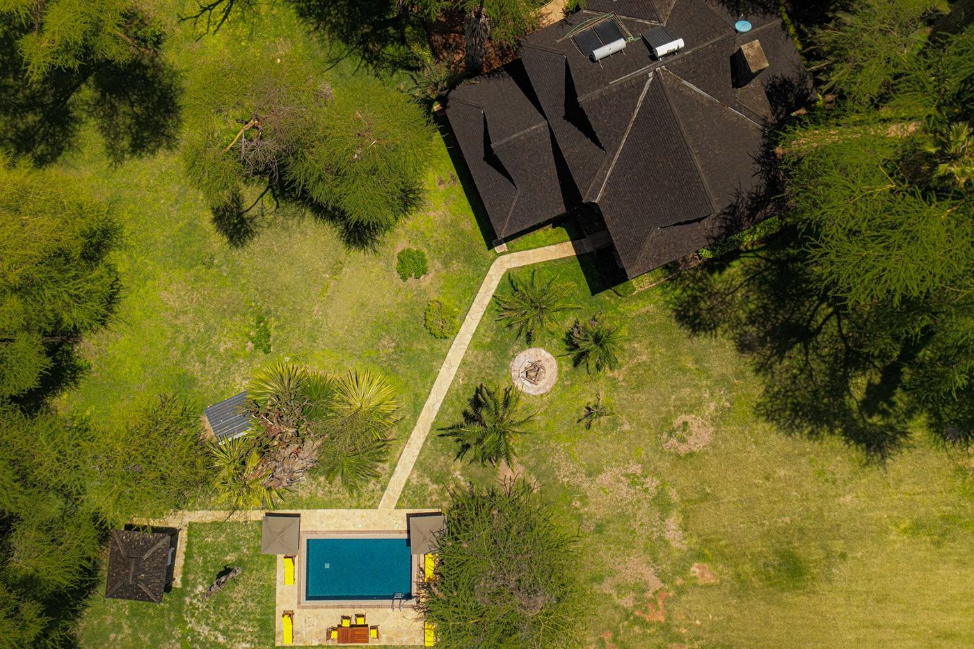 Aerial view of the villa's dark roof and gardens leading to the pool at Kibo Villa.