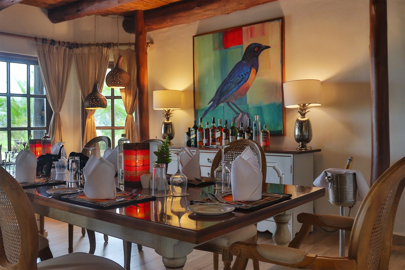 Formal dining table set for a meal beneath artwork at Kibo Villa.