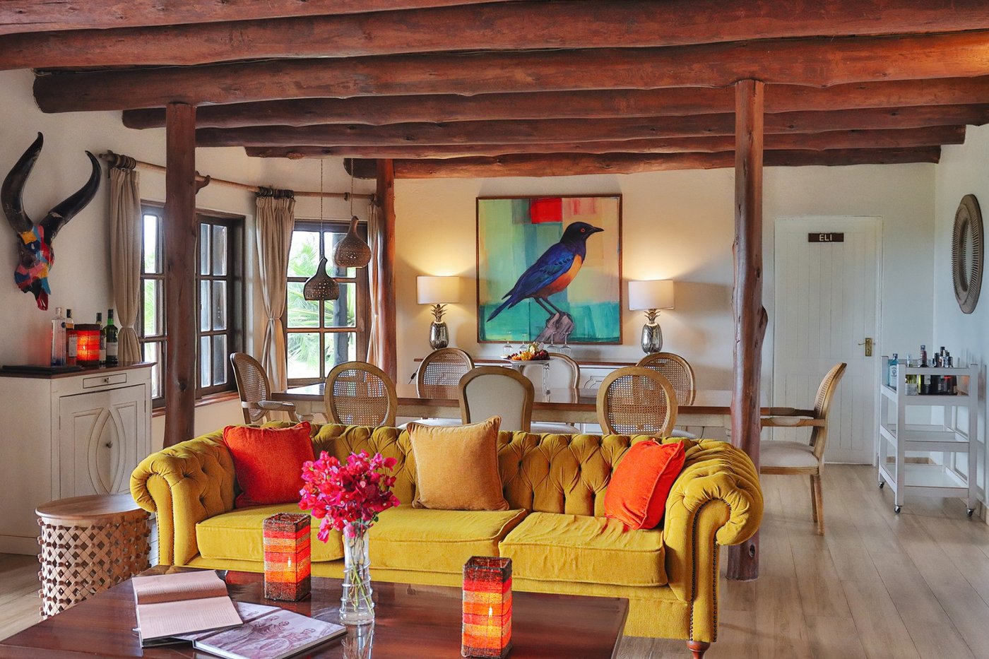 Mustard-yellow sofa and armchairs in a beamed lounge at Kibo Villa.