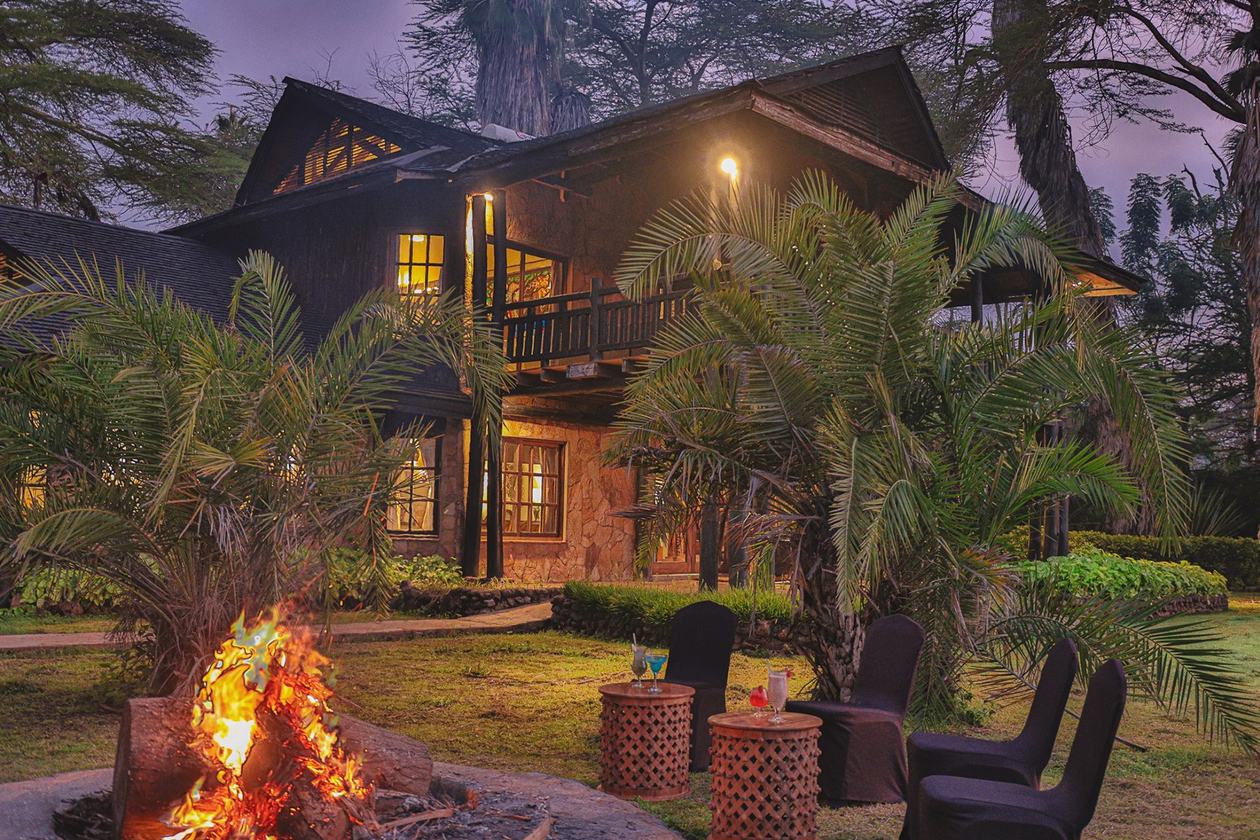 Villa lit up at dusk with a fire burning on the terrace at Kibo Villa.
