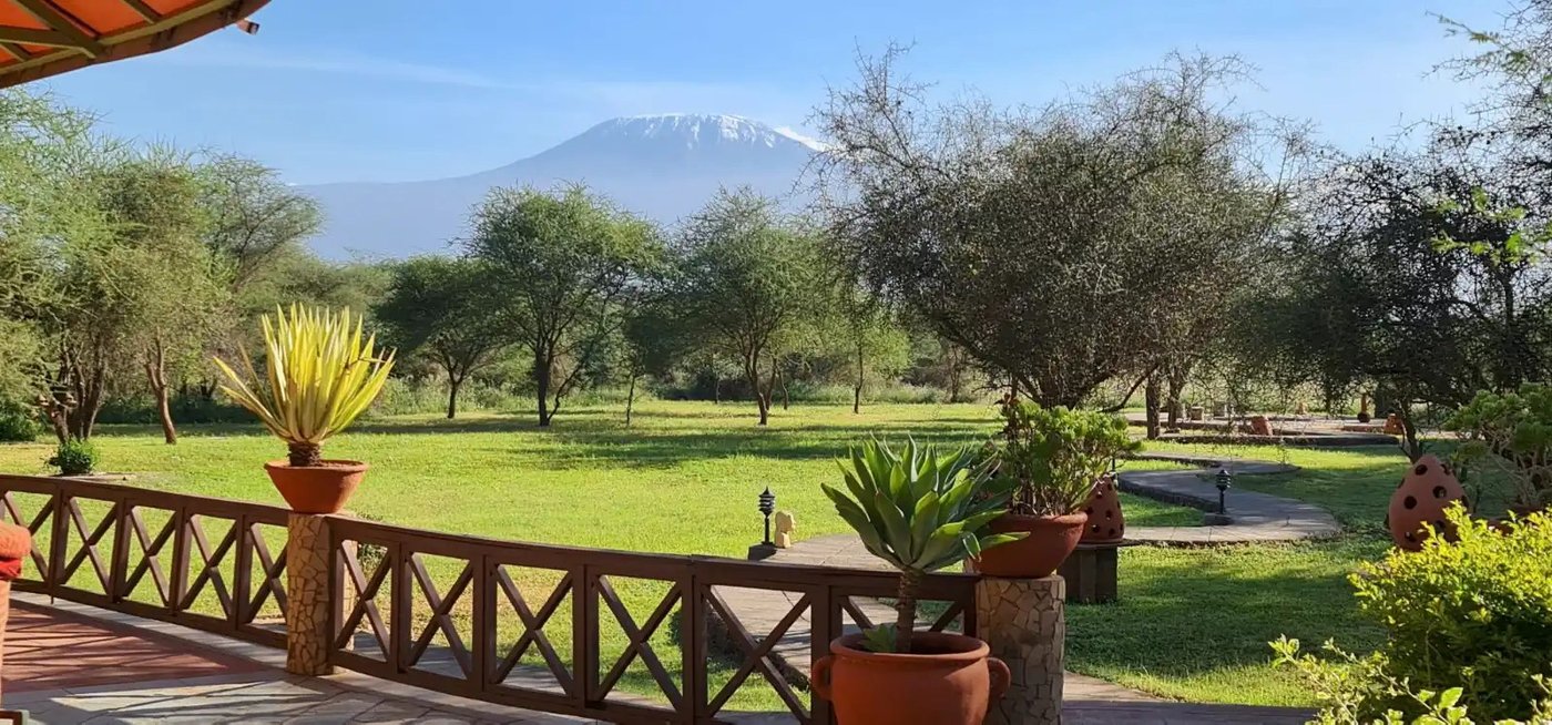 Wooden deck with railing and potted plants overlooking the gardens at Kilima Safari Camp.
