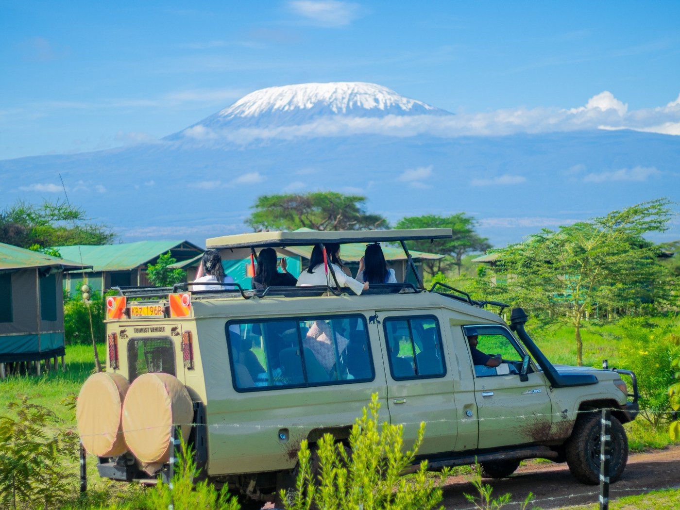 Safari vehicle parked near the tents with Kilimanjaro in view at Nyati Safari Camp.