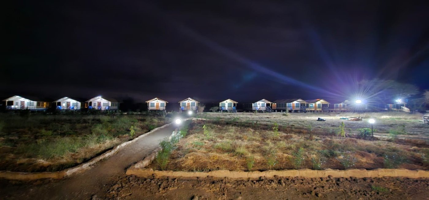 Camp walkway and tents lit up against the night sky at Nyati Safari Camp.