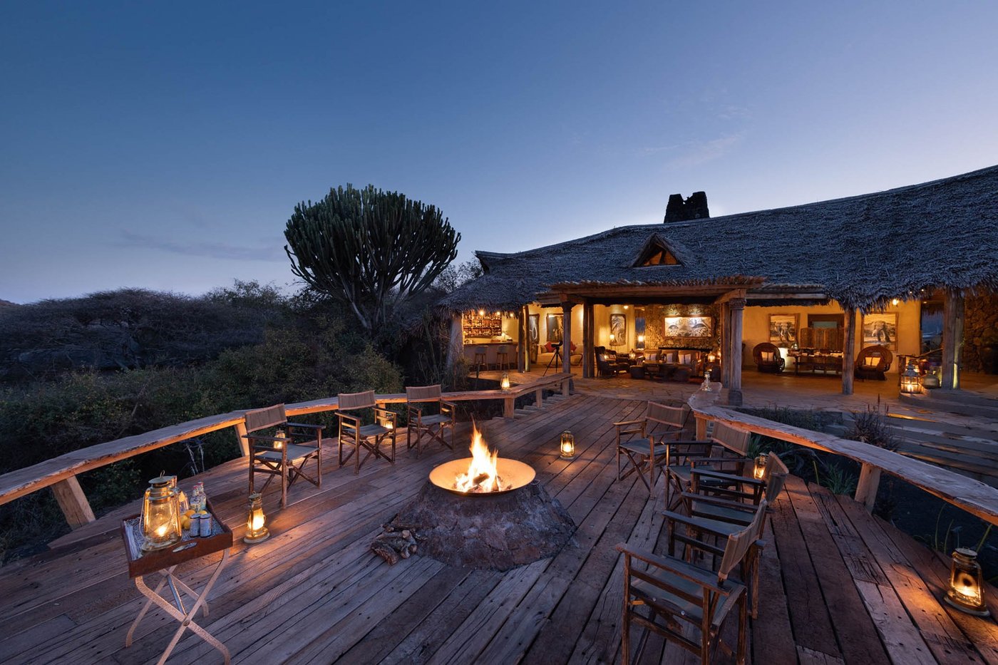 Fire pit lounge on an open deck overlooking the bush at sunset at ol Donyo Lodge, Amboseli.