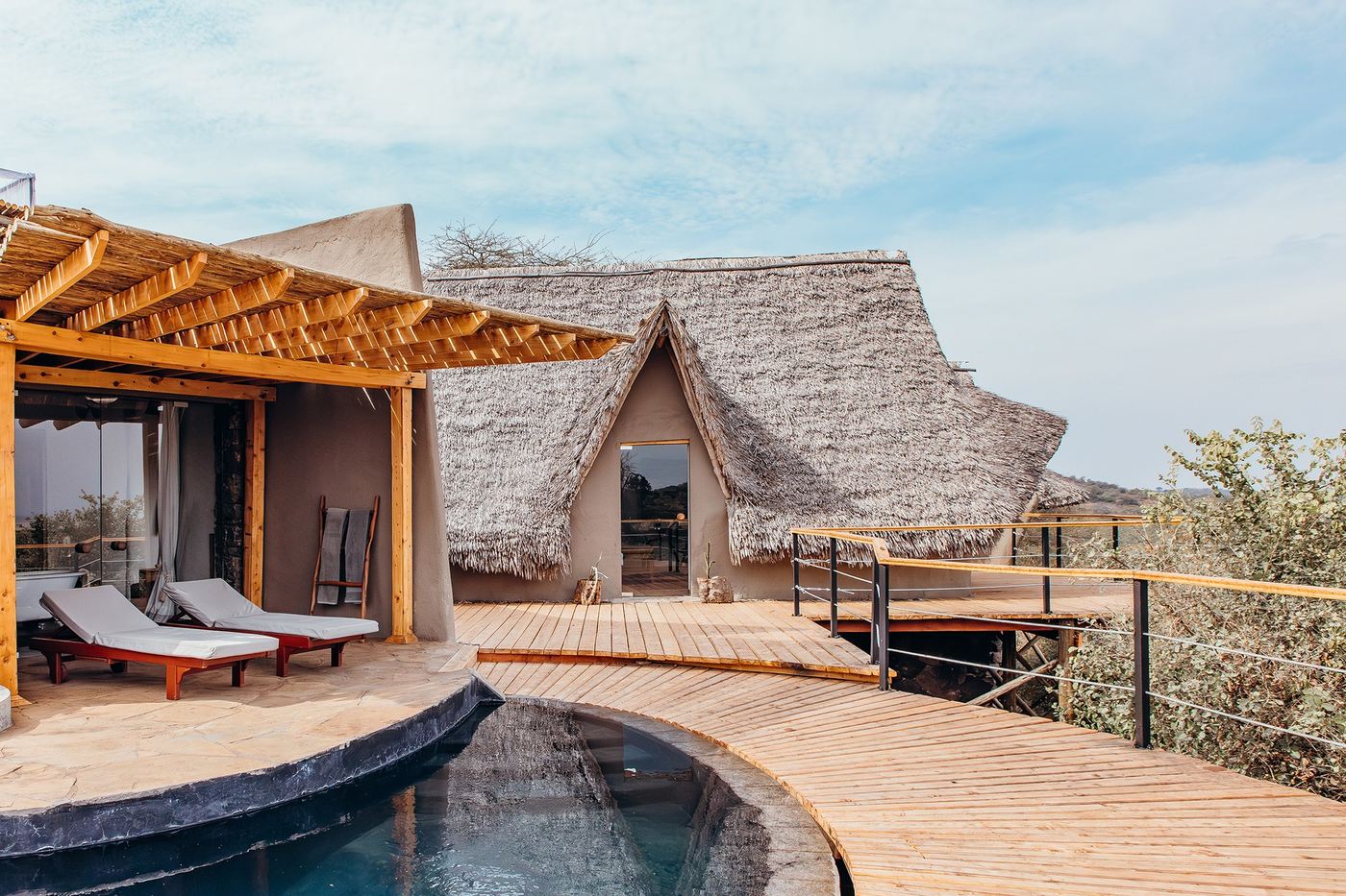 Thatched cottage with a private plunge pool and sun loungers at ol Donyo Lodge.