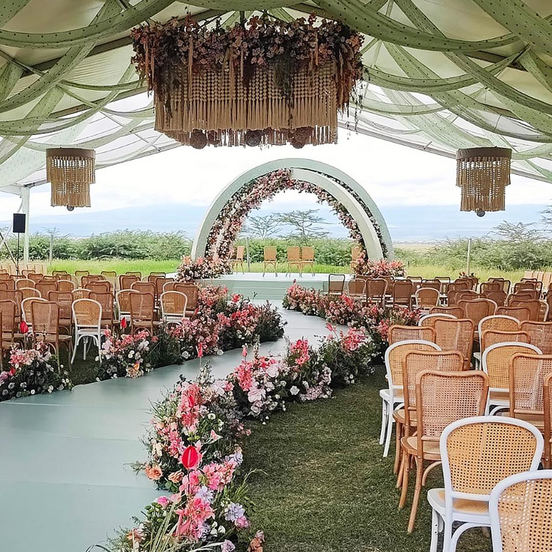 Floral archway and aisle seating set up on the lawn at Ol Tukai Lodge.