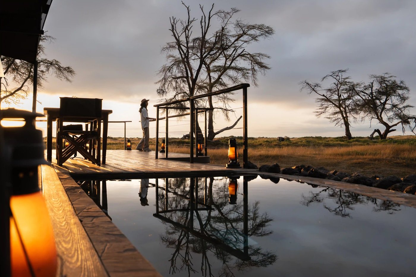 Wooden boardwalk reflected in still water at dusk at Soroi Amboseli.